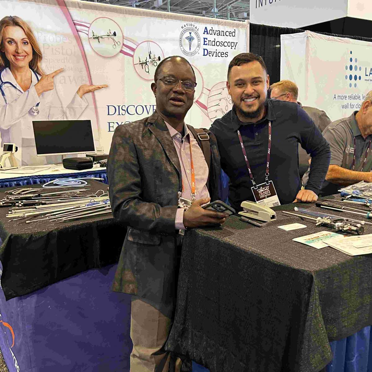 Advanced Endoscopy Devices at AAGL 2023 Photos Nashville - Two men taking a photo infront of banner